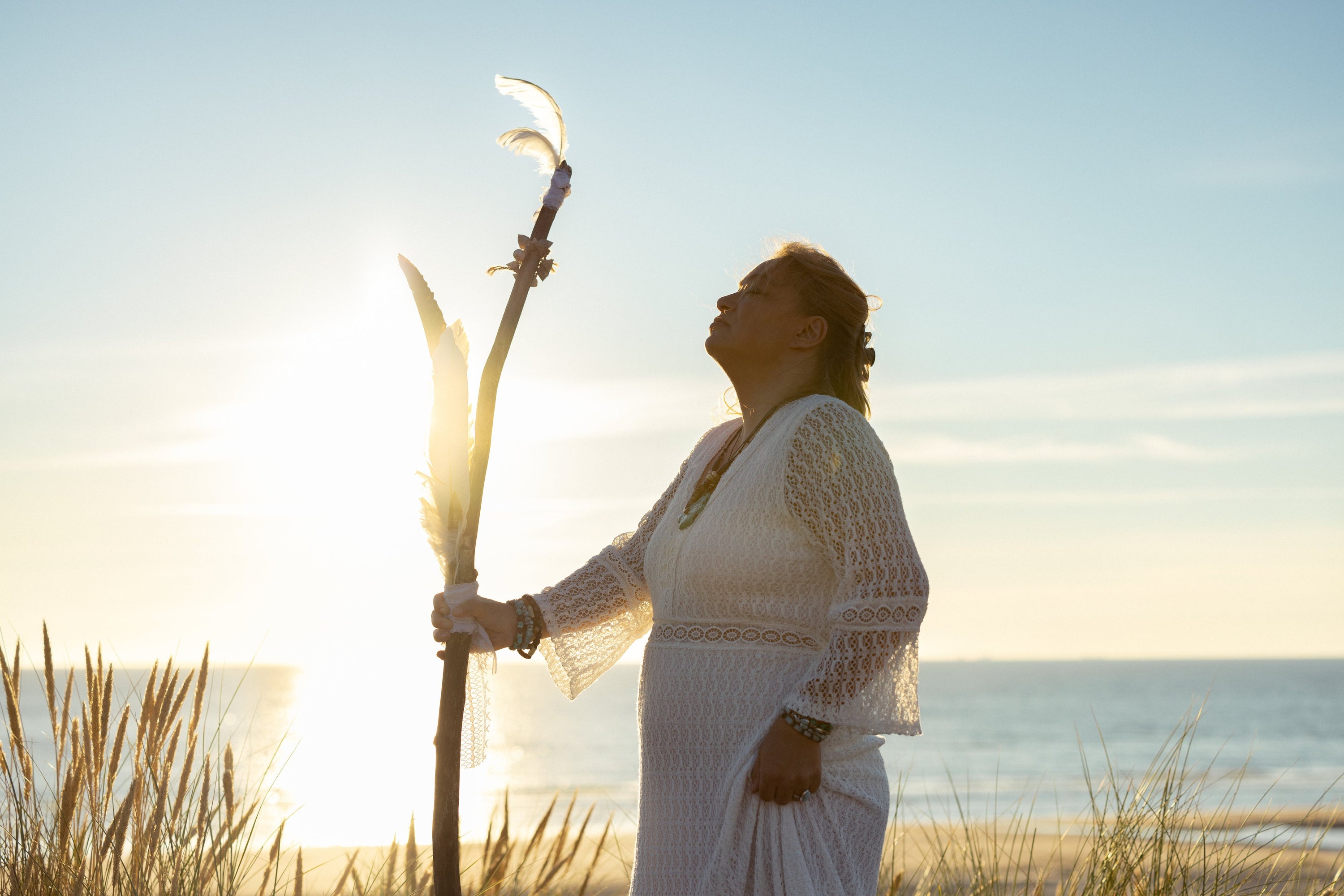 Spiritual Woman with wooden staff on the beach